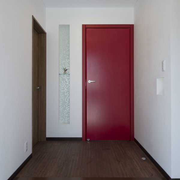 玄関ドアを開けるとイタリア製の赤いドアが印象的です。