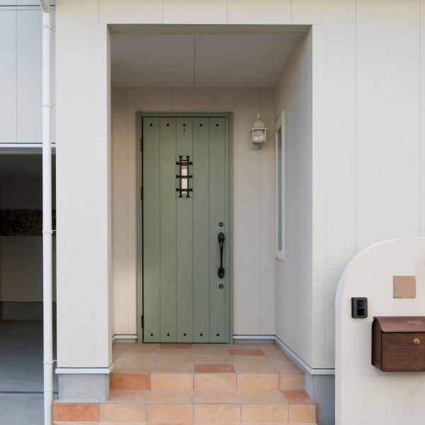 緑色の玄関ドアと優しい色合いのタイルで可愛らしい玄関です。