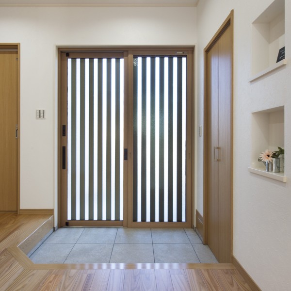 木目柄の玄関引き戸が素材感溢れる温かみのある玄関を演出します。